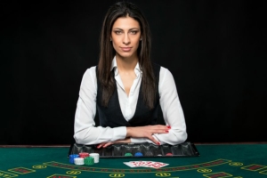 article-1-blackjack-dealers (1) White female dealer sitting arms folded at blackjack table
